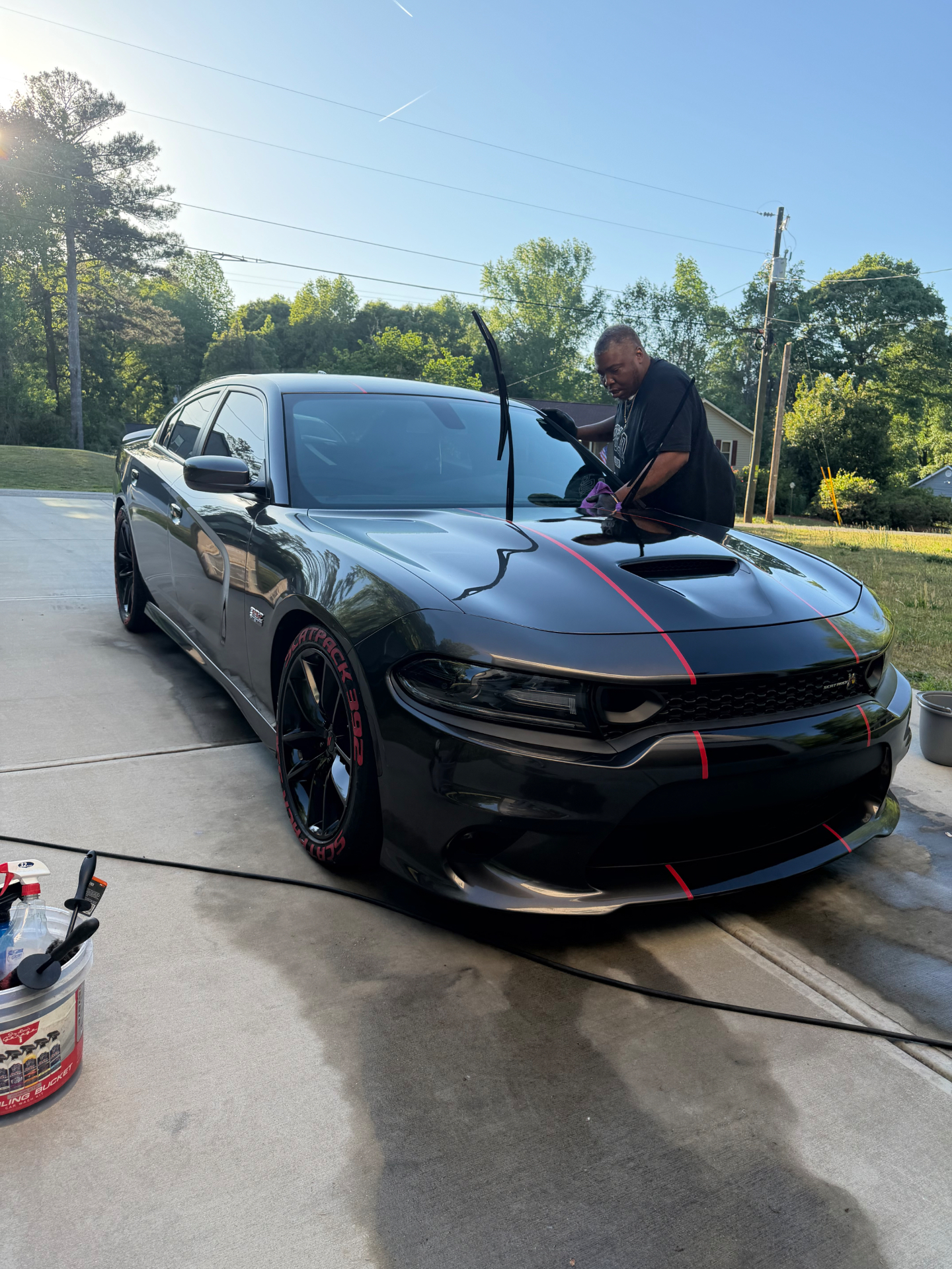 Owner hand-detailing a black Dodge Charger Scat Pack